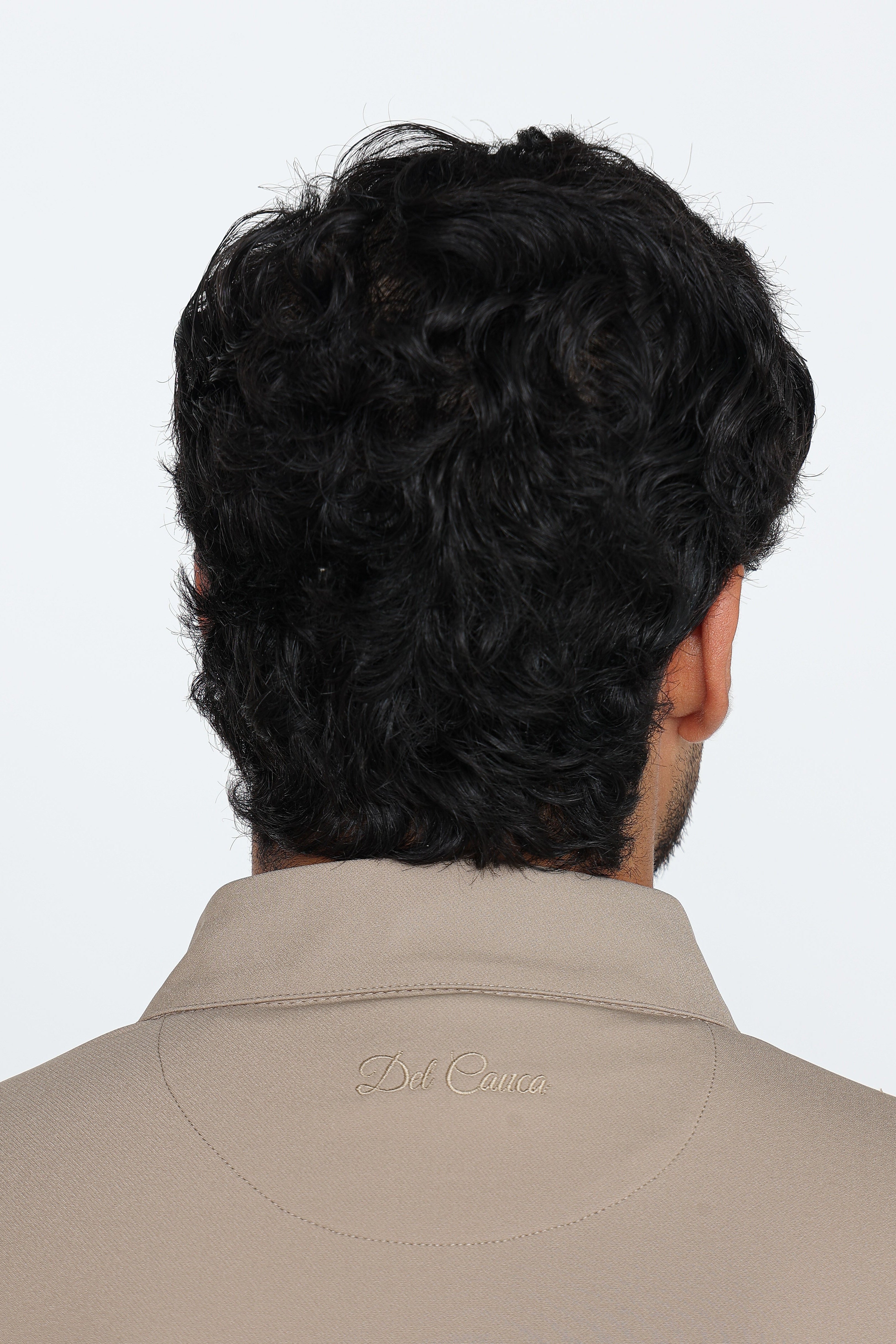 Man wearing a beige jacket with a brand logo on a white background