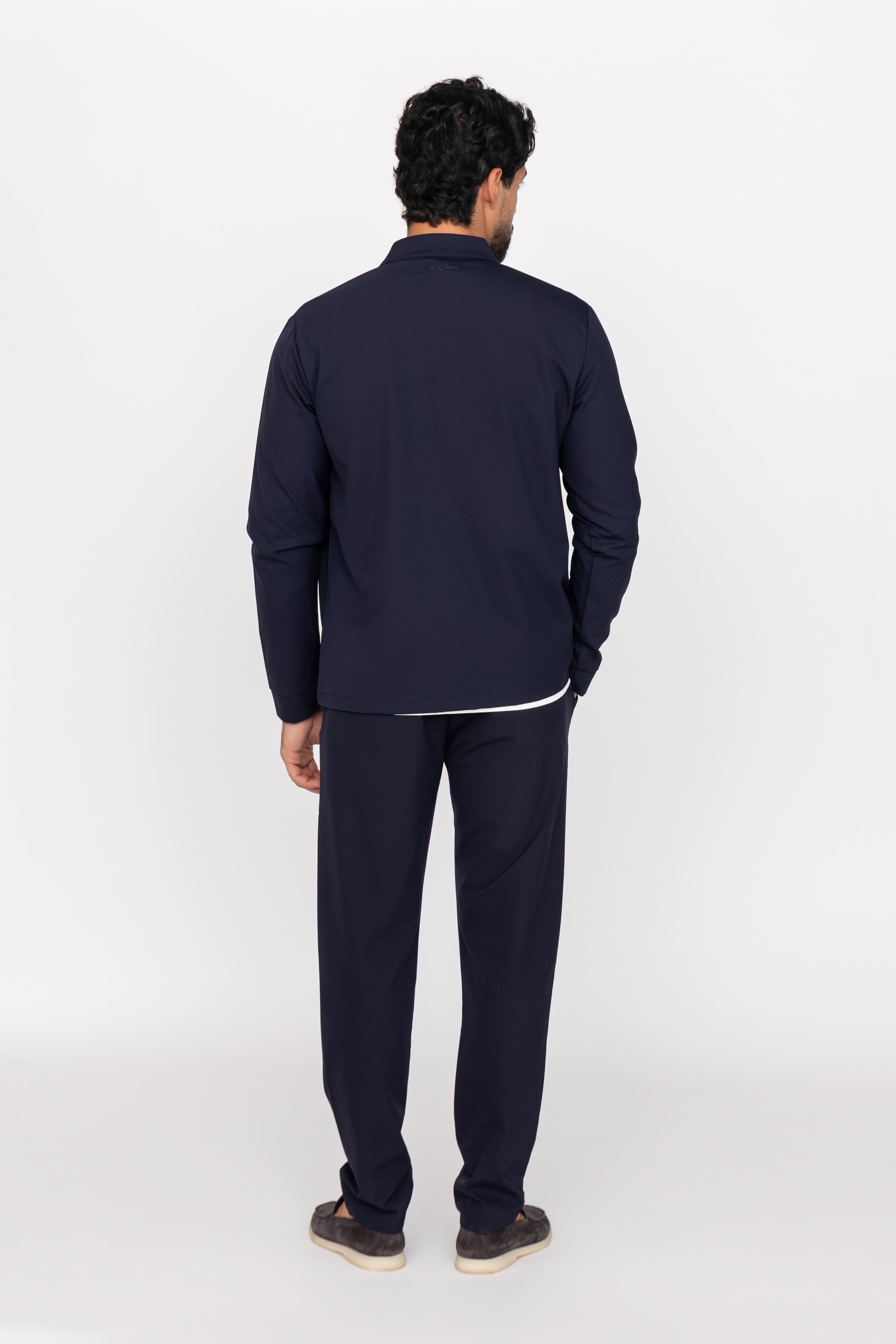 Person wearing a navy tracksuit on a white background