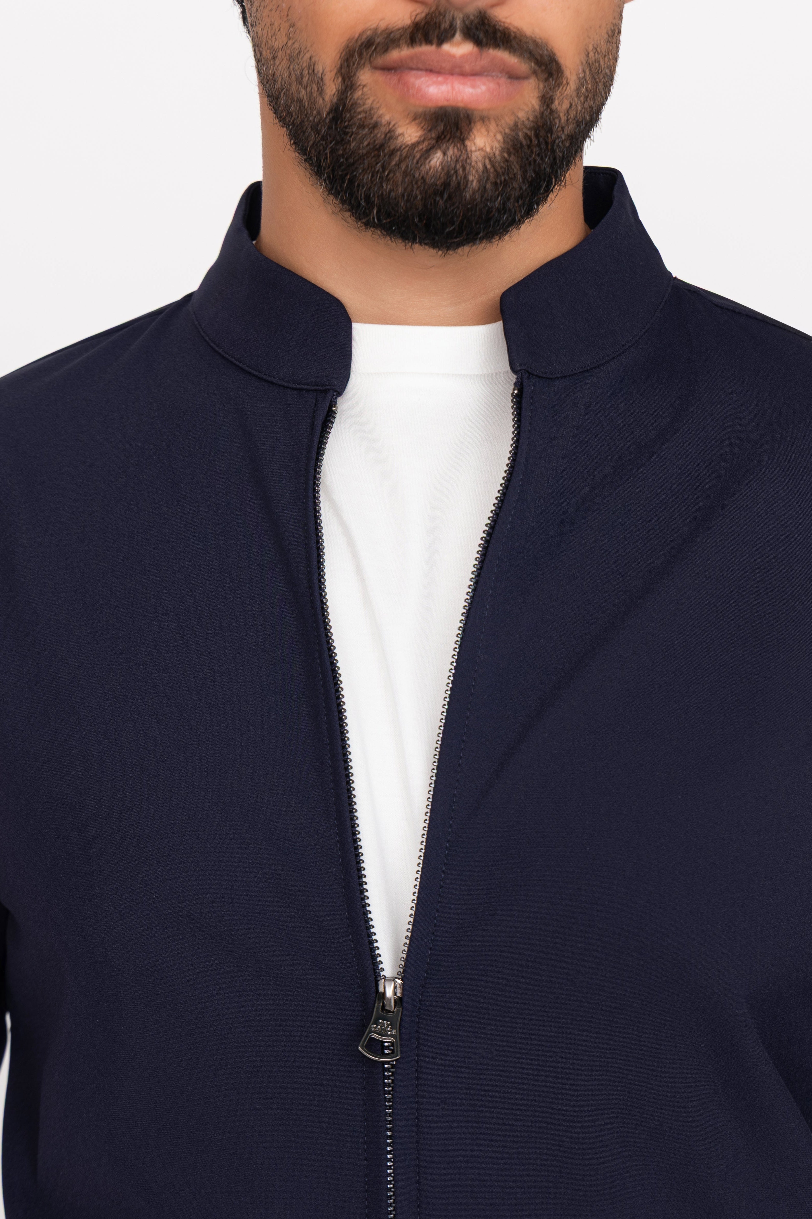 Navy blue jacket worn by a person on a white background
